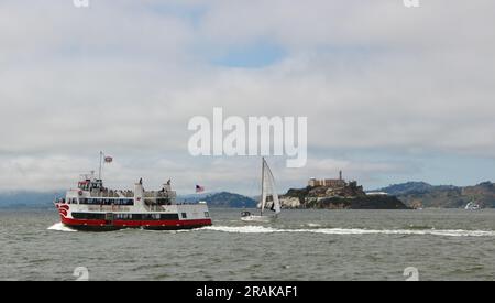 Tour in barca della Royal Prince Red and White Fleet in corso nella baia di San Francisco con l'isola di Alcatraz e uno yacht di passaggio San Francisco California USA Foto Stock
