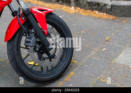 Ruota anteriore di una motocicletta rossa con freni a disco. Primo piano. Foto Stock
