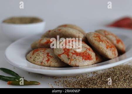 Bajra di carote. Torta di riso salata al vapore preparata da una pastella di lenticchie nere fermentate e miglio perlato non lucido con carr appena grattugiato Foto Stock