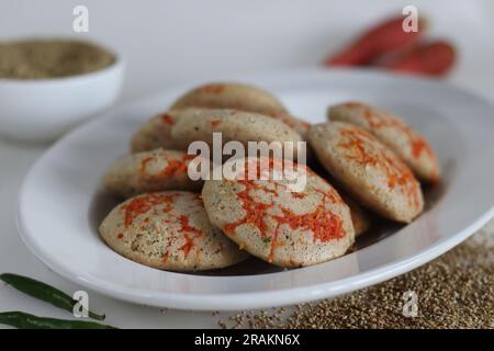 Bajra di carote. Torta di riso salata al vapore preparata da una pastella di lenticchie nere fermentate e miglio perlato non lucido con carr appena grattugiato Foto Stock