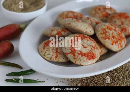 Bajra di carote. Torta di riso salata al vapore preparata da una pastella di lenticchie nere fermentate e miglio perlato non lucido con carr appena grattugiato Foto Stock