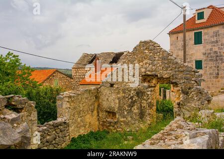 Una strada di case storiche in pietra abbandonate nel villaggio di Loziscz nel centro dell'isola di Brac in Croazia Foto Stock