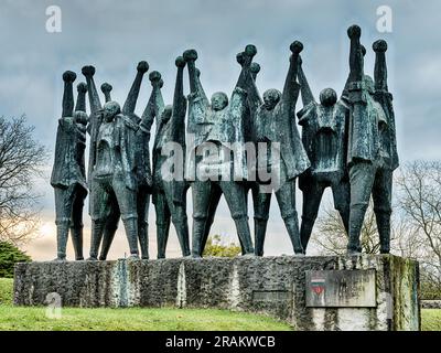 MAUTHAUSEN, AUSTRIA - 4 DICEMBRE 2022: Un grande memoriale alle vittime ungheresi nel campo di concentramento di Mauthausen mostra un gruppo di persone con fi Foto Stock