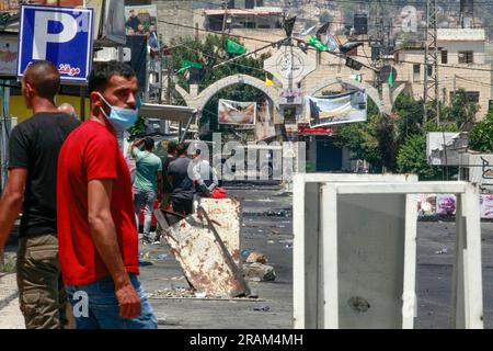 Jenin, Palestina. 4 luglio 2023. I palestinesi guardano a una Jeep militare israeliana mentre bloccano l'ingresso del campo profughi di Jenin. Funzionari sanitari palestinesi hanno detto che almeno 10 palestinesi sono stati uccisi in incursioni e attacchi aerei israeliani. Il portavoce dell'esercito, il retroammiraglio Daniel Hagari, ha affermato che Israele ha lanciato l'operazione perché circa 50 attacchi nell'ultimo anno erano stati sferrati da Jenin. (Foto di Nasser Ishtayeh/SOPA Images/Sipa USA) credito: SIPA USA/Alamy Live News Foto Stock