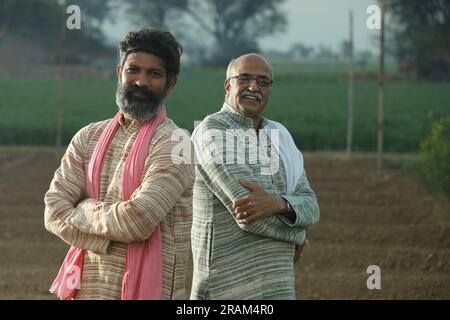 Splendida composizione di due agricoltori indiani in piedi nel campo con le mani piegate. Concetto agricolo che ritrae gli agricoltori al lavoro. Foto Stock