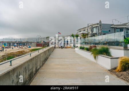 Pismo Beach, California, USA - 2 luglio 2023. Pismo Promenade al tramonto. I turisti possono godere della vista dell'oceano Pacifico e degli hotel sul lato della spiaggia. Foto Stock