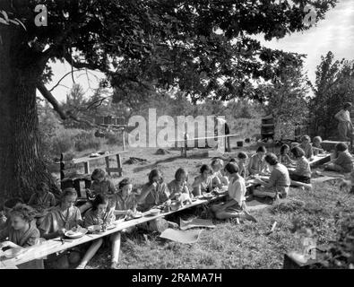 East Hartland, Connecticut: c. 1924. Le Junior Girl Scout di Camp Merritt preparano i loro pranzi e li divertono. Foto Stock