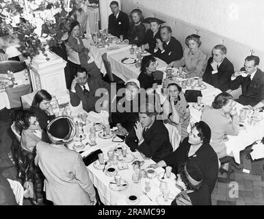 Stati Uniti: 1950 Un pranzo in un ristorante con una donna che parla agli ospiti. Foto Stock