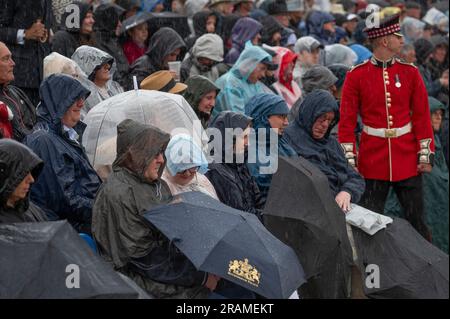 Horse Guards Parade, Londra, Regno Unito. 4 luglio 2023. La prima serata di spettacolo musicale militare Orb and Sceptre, aperto al pubblico, si svolge in forte pioggia e presenta le bande delle divisioni Household, Le pipe e i tamburi del Royal Yeomanry e della King's Troop Royal Horse Artillery in una parata di guardie a cavallo bagnata dalla pioggia ma con un pubblico affollato. Crediti: Malcolm Park/Alamy Live News Foto Stock