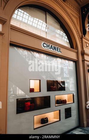 Elegante vetrina della boutique Chanel beige Stand con borse nella finestra di un negozio di lusso. Marchio di alta moda fondato da Coco Chanel nel 1909 Foto Stock