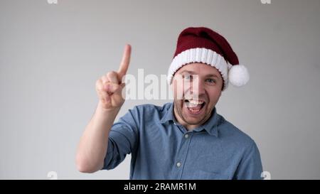 Funny Man in a New Year's Hat Counts Fingers, come mostra i numeri Foto Stock