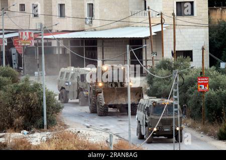 Jenin, Palestina. 4 luglio 2023. Decine di veicoli militari israeliani lasciano il campo profughi di Jenin, mentre decine di altri veicoli assaltano il campo contemporaneamente. Funzionari sanitari palestinesi hanno detto che almeno 10 palestinesi sono stati uccisi in incursioni e attacchi aerei israeliani. Il portavoce dell'esercito, il retroammiraglio Daniel Hagari, ha affermato che Israele ha lanciato l'operazione perché circa 50 attacchi nell'ultimo anno erano stati sferrati da Jenin. Credito: SOPA Images Limited/Alamy Live News Foto Stock