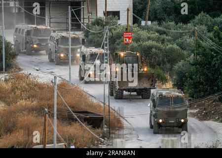 Jenin, Palestina. 4 luglio 2023. Decine di veicoli militari israeliani lasciano il campo profughi di Jenin, mentre decine di altri veicoli assaltano il campo contemporaneamente. Funzionari sanitari palestinesi hanno detto che almeno 10 palestinesi sono stati uccisi in incursioni e attacchi aerei israeliani. Il portavoce dell'esercito, il retroammiraglio Daniel Hagari, ha affermato che Israele ha lanciato l'operazione perché circa 50 attacchi nell'ultimo anno erano stati sferrati da Jenin. Credito: SOPA Images Limited/Alamy Live News Foto Stock