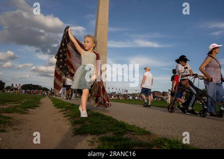 Washington, Stati Uniti. 4 luglio 2023. Sophia Liddiard, di quattro anni e mezzo, di Long Beach, California, porta una bandiera americana mentre la folla si riunisce per guardare l'annuale spettacolo pirotecnico del 4 luglio sul National Mall di Washington DC martedì 4 luglio 2023. Foto di Ken Cedeno/UPI Credit: UPI/Alamy Live News Foto Stock