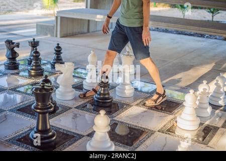 Padre e figlio giocano a scacchi e trascorrono del tempo insieme all'aperto. I bambini giocano a scacchi Foto Stock