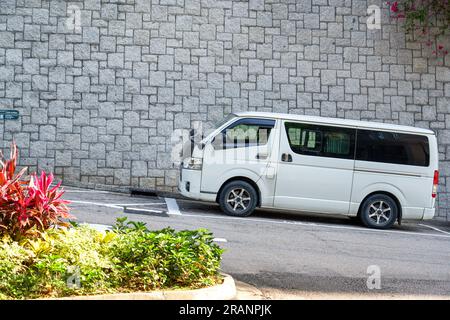 Un classico furgone bianco parcheggiato sulla metà della strada di Hong Kong Foto Stock