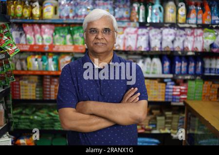 Ritratto di un anziano indiano felice e sorridente che acquista in un negozio di alimentari. Nonno sicuro e in forma che acquista generi alimentari per casa in un supermercato. Foto Stock