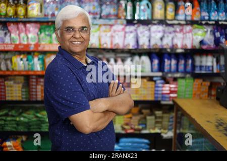 Ritratto di un anziano indiano felice e sorridente che acquista in un negozio di alimentari. Nonno sicuro e in forma che acquista generi alimentari per casa in un supermercato. Foto Stock