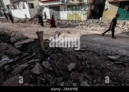 Jenin, territori palestinesi. 5 luglio 2023. I palestinesi camminano tra i danni al campo profughi di Jenin dopo l'operazione militare israeliana su larga scala nella città di Jenin in Cisgiordania. 12 palestinesi sono stati uccisi e più di 120 feriti. Credito: Ayman Nobani/dpa/Alamy Live News Foto Stock