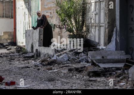 Jenin, territori palestinesi. 5 luglio 2023. Una donna palestinese ispeziona i danni al campo profughi di Jenin dopo l'operazione militare israeliana su larga scala nella città di Jenin in Cisgiordania. 12 palestinesi sono stati uccisi e più di 120 feriti. Credito: Ayman Nobani/dpa/Alamy Live News Foto Stock