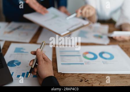 Riunione di consulenti aziendali asiatici per analizzare e discutere la situazione sul rapporto finanziario nella sala riunioni.Consulente investimenti Foto Stock