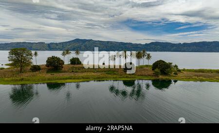 Vista aerea dello splendido lago Toba e di un'isola con palme. Samosir, Pulau Toba. Sumatra, Indonesia. Foto Stock