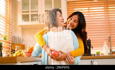 felice nonna di famiglia con ritratto di figlia. famiglia allegra in cucina sorridente insieme. Foto Stock