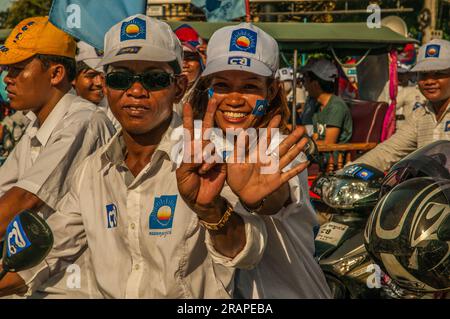 Una coppia cambogiana, i sostenitori di Sam Rainsy, mostrando #7 con le loro mani durante un raduno motociclistico politico. Phnom Penh, Cambogia. © Kraig Lieb Foto Stock