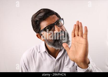 Ritratto di un uomo barbuto indiano che indossa una camicia. Espressioni funky tristi e sgradevoli, piene di rabbia e aggressività. Foto Stock