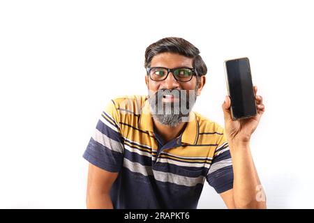 Ritratto di un uomo indiano barbuto che indossa occhiali e t-shirt. Espressioni funky volto distorto. Uomo sbalordito che mostra vari stati d'animo di stravagante personalità. Foto Stock