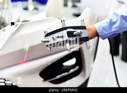 Gli scanner laser 3D portatili misurano la precisione delle parti automobilistiche. negli impianti industriali. Foto Stock