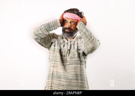 Ritratto di un uomo barbuto indiano nel concetto rurale dell'India. Espressioni funky sfondo bianco. povero abitante del villaggio. varie espressioni e stati d'animo di povertà Foto Stock