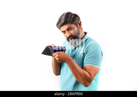 Ritratto di un uomo indiano barbuto che indossa una camicia con un portafoglio vuoto. Espressioni Wacky e Funky sfondo bianco. povertà e niente soldi e niente soldi. Foto Stock