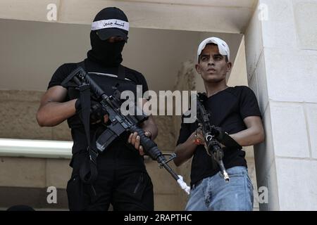 Jenin, territori palestinesi. 5 luglio 2023. I militanti palestinesi sono in piedi durante i funerali di persone uccise dalle forze israeliane in Cisgiordania. Nove persone sono state uccise nel più grande schieramento israeliano in Cisgiordania negli ultimi 20 anni, mentre migliaia si sono riunite a Jenin per i loro funerali mercoledì. Credito: Ayman Nobani/dpa/Alamy Live News Foto Stock