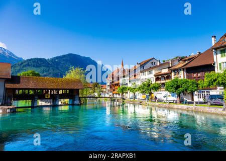 Grosse Staatsschleuse ponte coperto, case sulla riva del fiume Aare, Unterseen, Svizzera Foto Stock