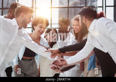 Angolo di Alta Vista multirazziale amico di impilaggio assieme a mano Foto Stock