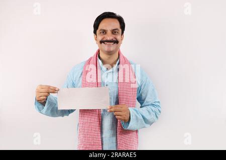 Ritratto di un felice agricoltore indiano nel concetto rurale dell'India. Su uno sfondo bianco, l'allegro agricoltore sta dando un'azione mozzafiato e si sente orgoglioso Foto Stock