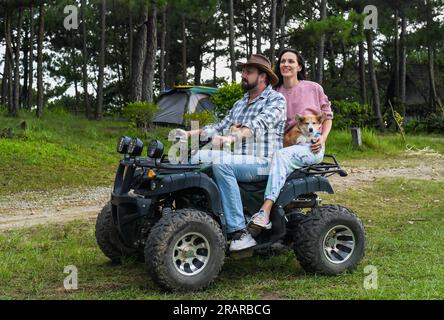 Ritratto di una giovane coppia sposata seduta su un quad nella foresta Foto Stock