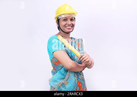 Indiano rurale villager donna che si prepara a diventare un ingegnere in futuro. La donna indossa un casco tecnico. Foto Stock