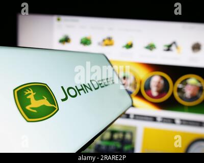 Smartphone con logo dell'azienda americana Deere Company (John Deere) sullo schermo davanti al sito Web aziendale. Mettere a fuoco sul lato sinistro del display del telefono. Foto Stock