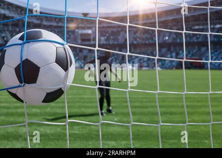 il giocatore di calcio calcia la palla nel gol dello stadio Foto Stock