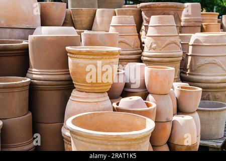 Una varietà di vasi di fiori di terracotta impilati vuoti in diverse dimensioni e forme in vendita presso il centro giardino Foto Stock