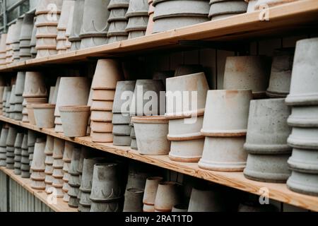 Una varietà di vasi di fiori decorativi vuoti in ceramica di diverse dimensioni e forme in vendita sugli scaffali del centro del giardino Foto Stock