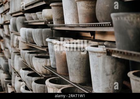 Una varietà di vasi di fiori decorativi vuoti in ceramica di diverse dimensioni e forme in vendita sugli scaffali del centro del giardino Foto Stock