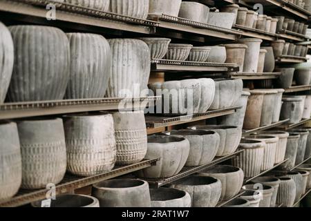 Una varietà di vasi di fiori decorativi vuoti in ceramica di diverse dimensioni e forme in vendita sugli scaffali del centro del giardino Foto Stock