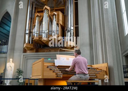 L'organista suona musica sull'organo della chiesa all'interno di Hallgrimskirkja Foto Stock