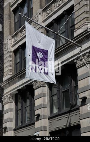 New York, NY - 24 giugno 2023: Bandiera della NYU sul lato di un edificio (logo della New York University) nel Greenwich Village, Manhattan. Foto Stock