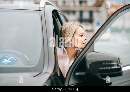 Bella donna che esce dalla macchina Foto Stock