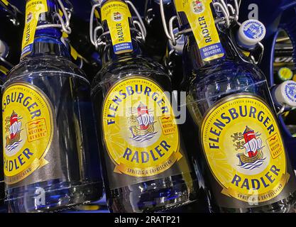 Viersen, Germania - 4 luglio. 2023: Primo piano di tre bottiglie di miscela di birra Flensburger Radler in cassa Foto Stock