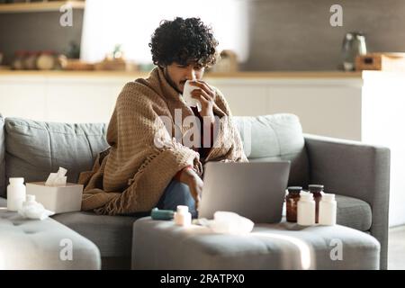 Malato indiano starnuto naso e alla ricerca di suggerimenti per il trattamento in Internet Foto Stock